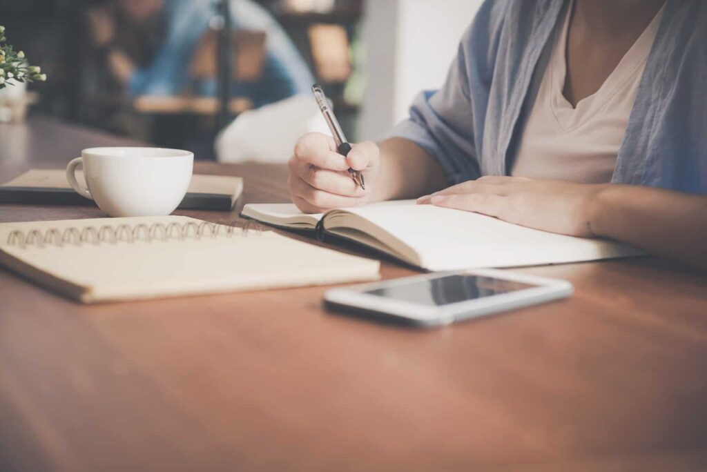 Content writer and copywriter sitting at a table with a coffee